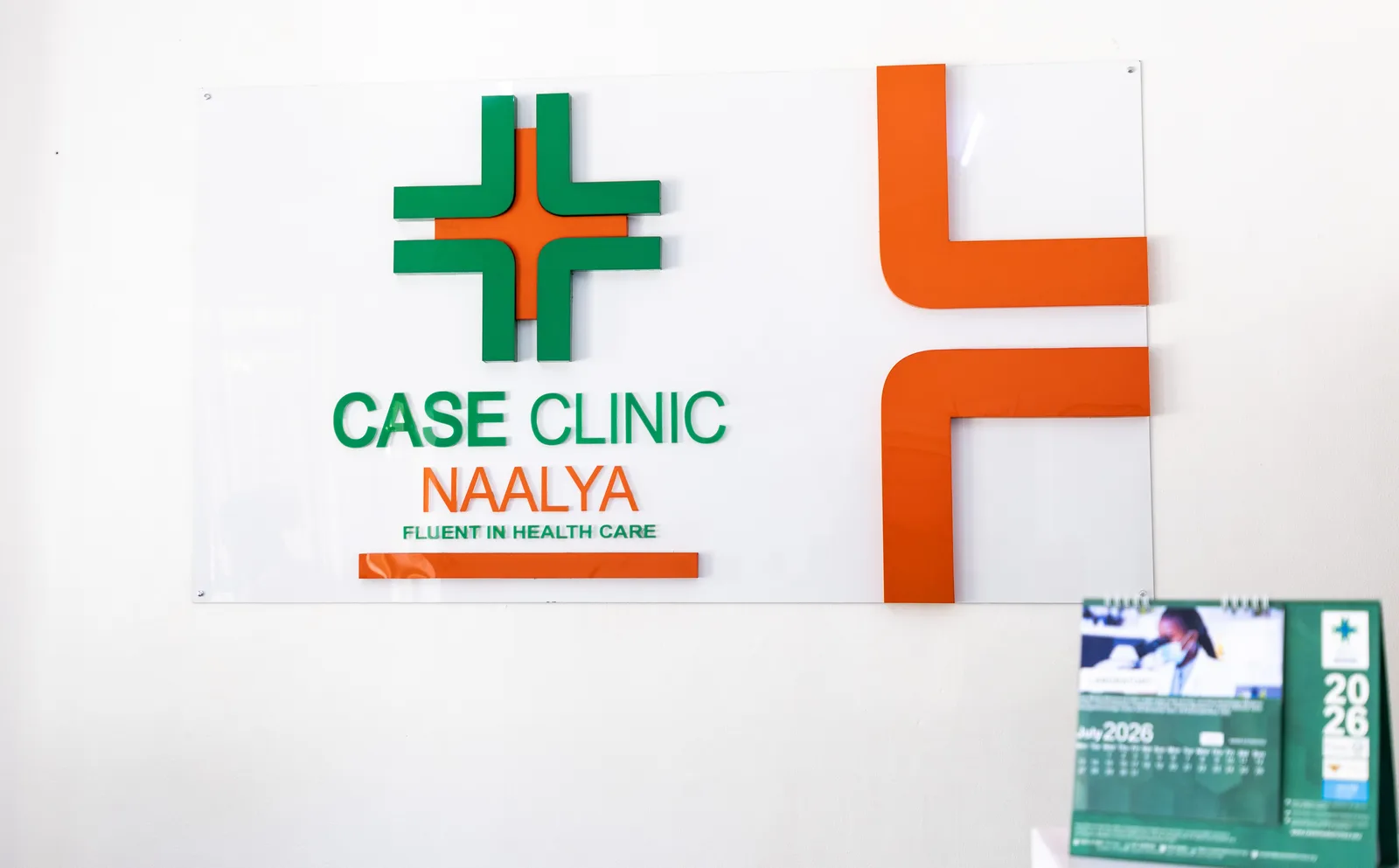 Orange and green Case Clinic Naalya wall identity